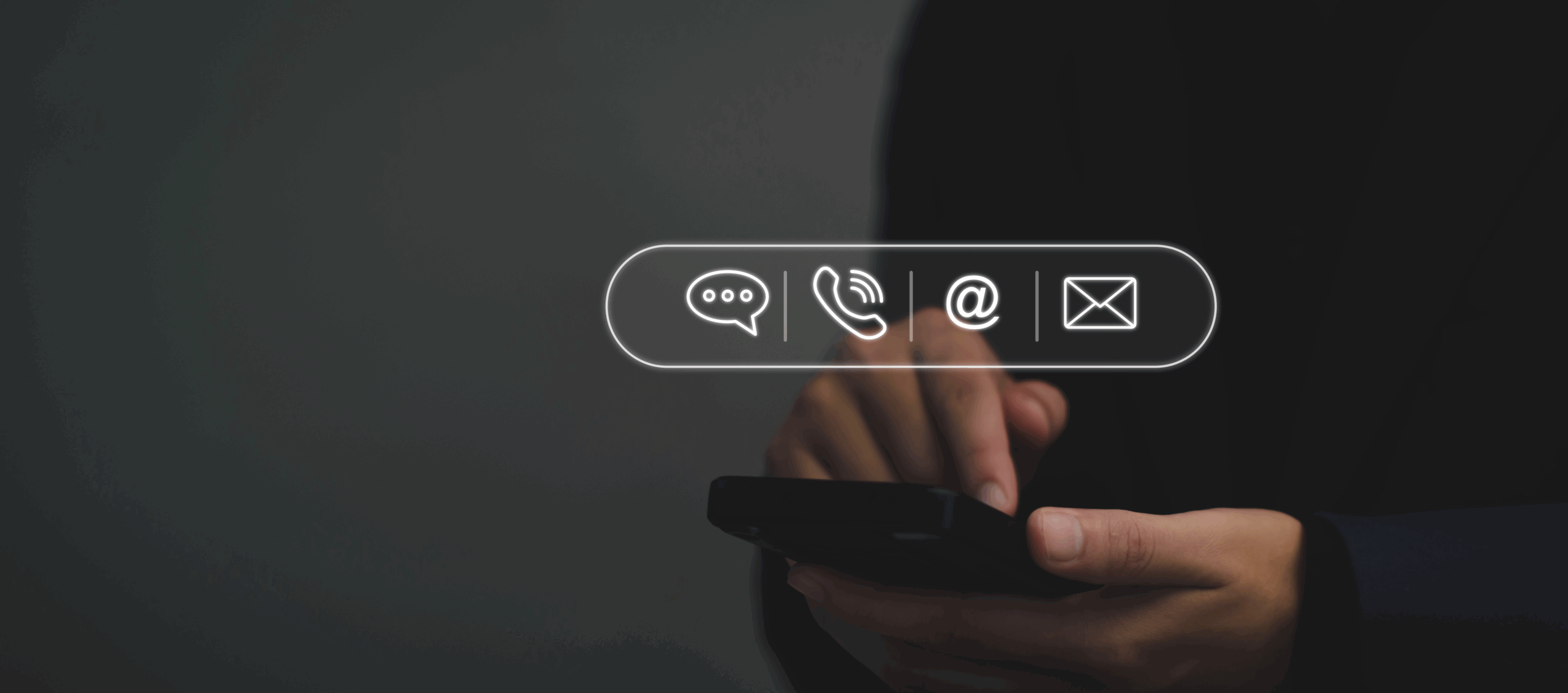 Close-up of hands using a smartphone with digital icons for chat, phone call, email, and message floating above the device against a dark background.